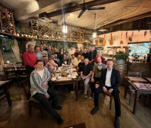 Uczestnicy zajęć Wing Tsun siedzą przy długim stole w restauracji po treningu