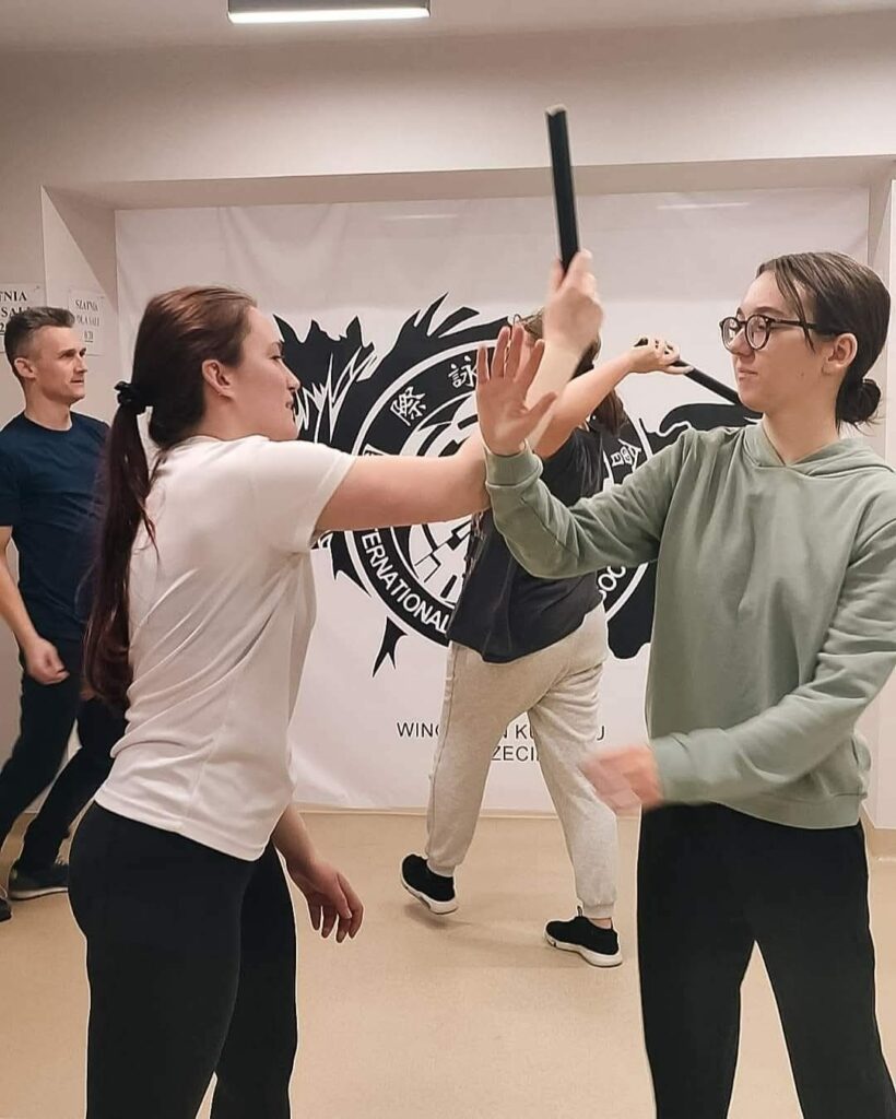 Szkolenie bezpieczeństwa dla szkół w Szczecinie Ćwiczenia z kijami w grupie podczas zajęć Wing Tsun Kung Fu w Szczecinie